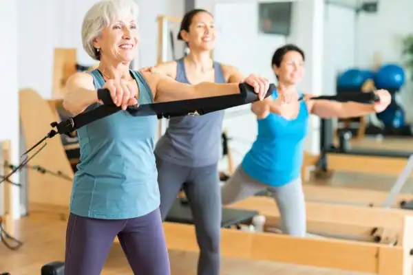 Toning Arms After 60: Empowering Womens Fitness Through Effective Weight Training 2 older woman doing weight training Halesowen and resistance in the gym to tone upper arms