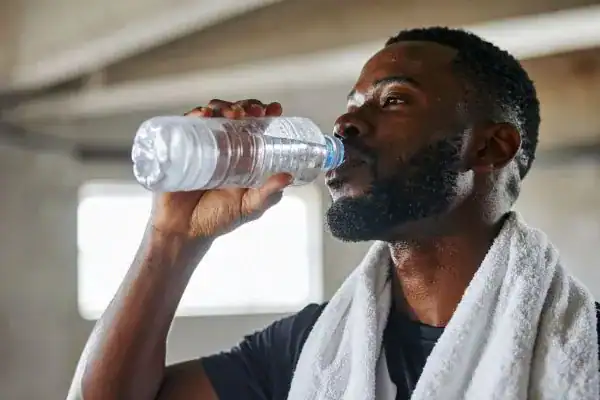 Image of man drinking water to improve hydration Halesowen after work out.